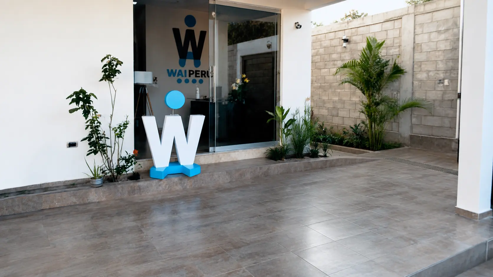 Sede de WAI Perú — entrada con la escultura del logo W